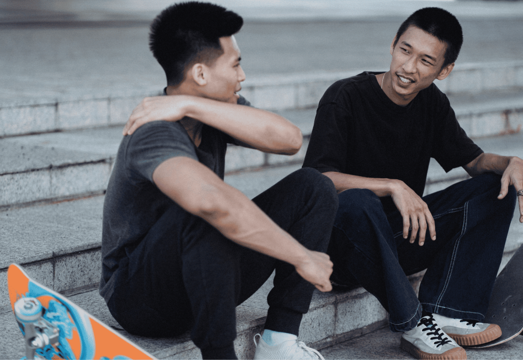 Two skateboarders sitting on stairs